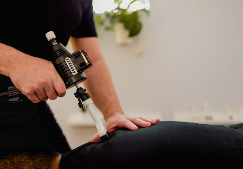 ArthroStim instrument adjusting — Optimum Chiropractic Care Mobile AL