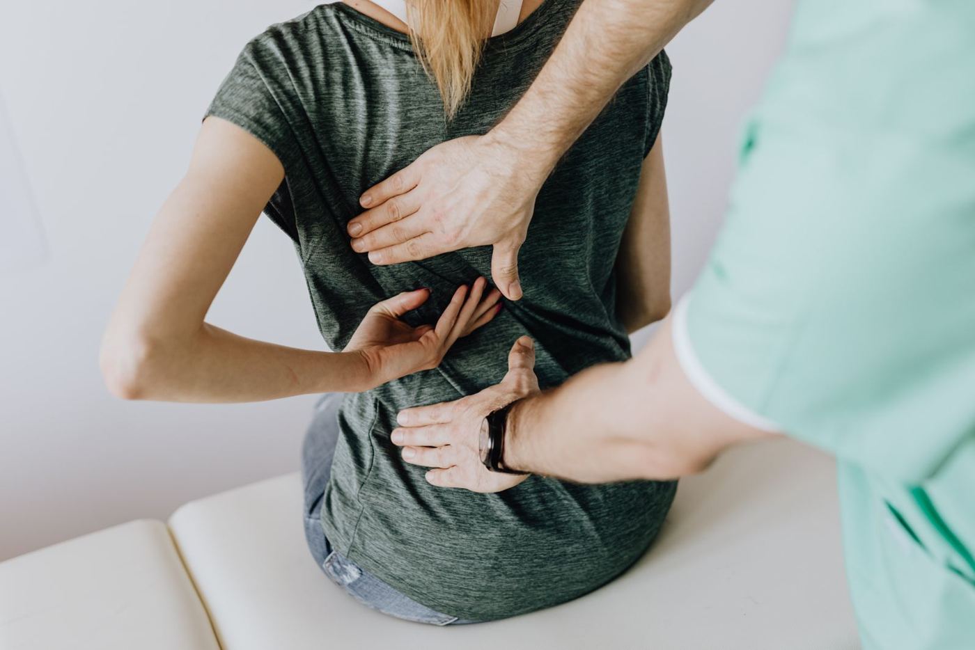Patient indicating an area of back pain during a clinical examination