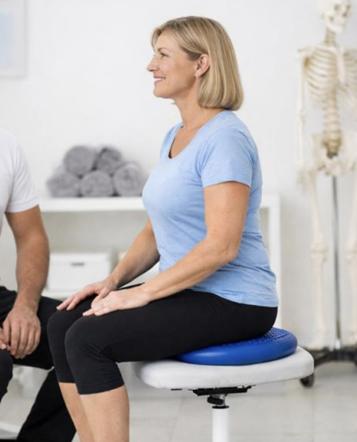 Patient performing physical therapy balance exercises on a wobble cushion